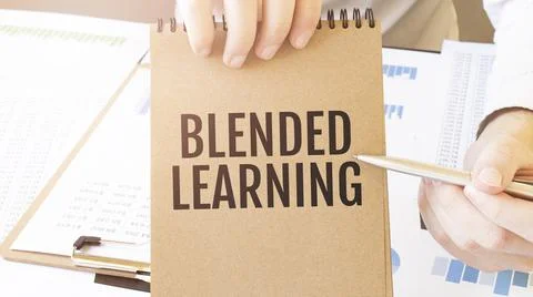 Text BLENDED LEARNING on brown paper notepad in businessman hands on the tabl Stock Photos