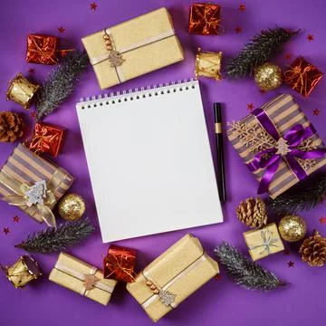 Text book with white empty pages among gift boxes and presents on violet Stock Photos