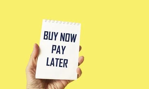 Text buy now pay later in hand on note and yellow background Stock Photos