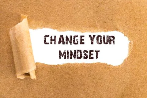The text CHANGE YOUR MINDSET  appearing behind torn brown paper Stock Photos
