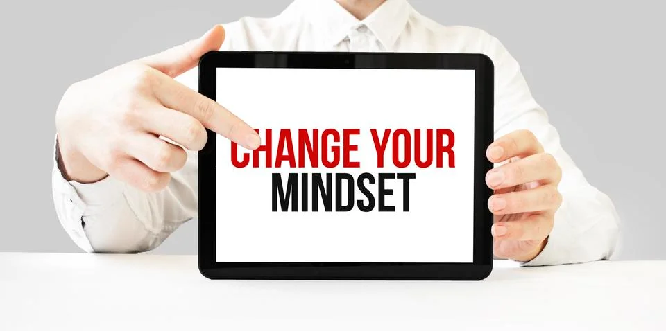 Text Change Your Mindset on tablet display in businessman hands on the white  Stock Photos