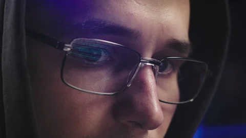 The text of the code is reflected in the hacker's glasses Stock Footage 179514989