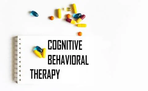The text "COGNITIVE BEHAVIORAL THERAPY" is written in a notebook next to pill Stock Photos