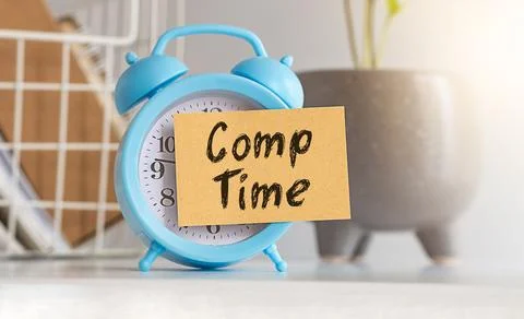 Text Comp Time on a Sticker glued to a blue alarm clock against the backgro.. Stock Photos