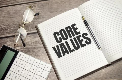 Text core values on brown diary with calculator, glasses on wooden background Foto stock