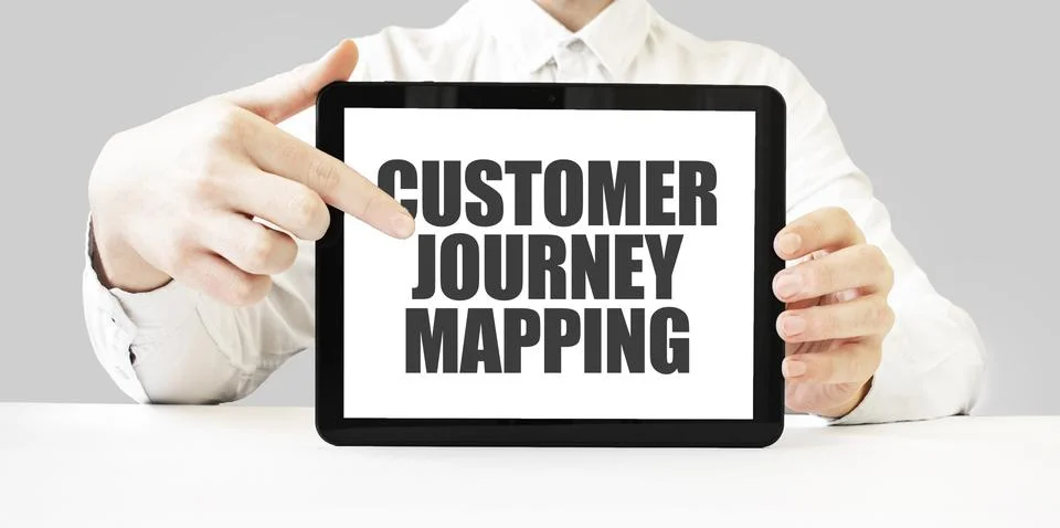 Text CUSTOMER JOURNEY MAPPING on tablet display in businessman hands on the.. Stock Photos