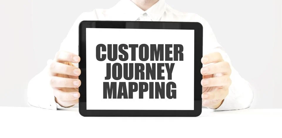 Text CUSTOMER JOURNEY MAPPING on tablet display in businessman hands on the.. Stock Photos