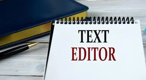 TEXT EDITOR - words in a notebook on the background of a weekly and a pen. Stock Photos