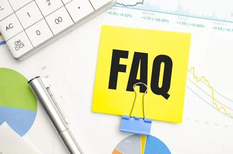 Text FAQS on blue paper on the table next to financial reports and calculator Stock Photos