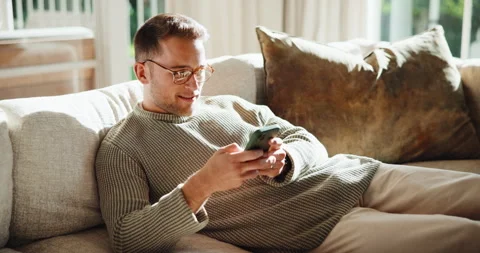 Text, glasses and man on sofa with phone, web search and online chat on social Stock Footage 341431482