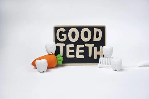 Text Good Teeth on Blackboard with Tooth, Carrot Model and White Toothbrush Stock Photos