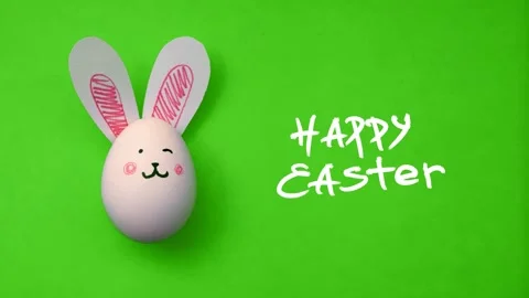 Text Happy Easter and chicken egg with cute bunny face on green background Stock Footage 302728156