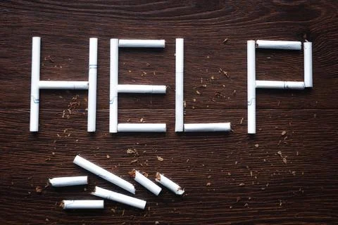 Text help made from broken cigarettes on wooden background Stock Photos