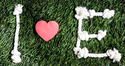 Text: I love E made from ropes on grass background. Stock Photos