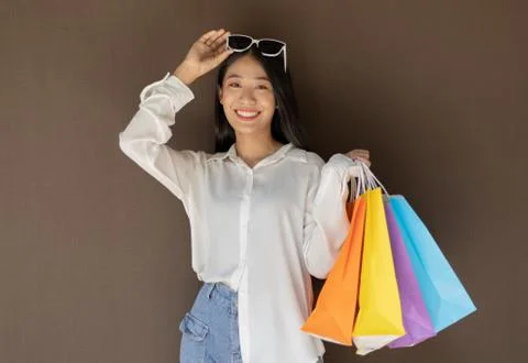 Text input box, Brown background, Young women carrying colorful shopping bags Stock Photos