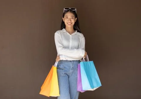 Text input box, Brown background, Young women carrying colorful shopping bags Stock Photos