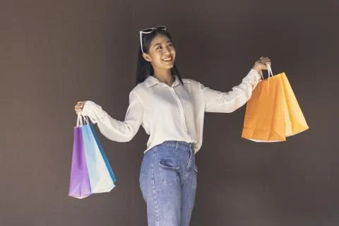 Text input box, Brown background, Young women carrying colorful shopping bags Stock Photos