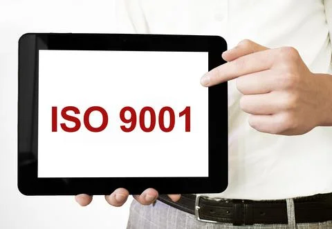 Text iso 9001 on tablet display in businessman hands on the white bakcground. Stock Photos