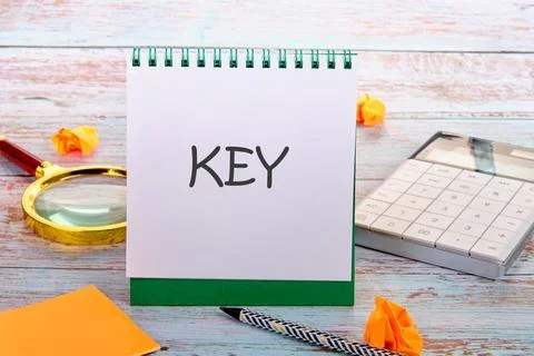 The text KEY in an upright notebook in a composition with office supplies Stock Photos