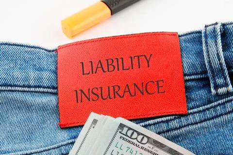 Text Liability Insurance on the leather insert of jeans with dollar bills sti Stock Photos
