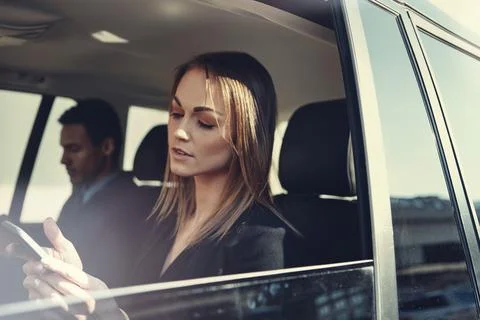 Text me your GPS coordinates. a young businesswoman using a mobile phone while Stock Photos