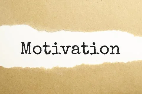 The text motivation appearing behind torn brown paper Fotos de archivo