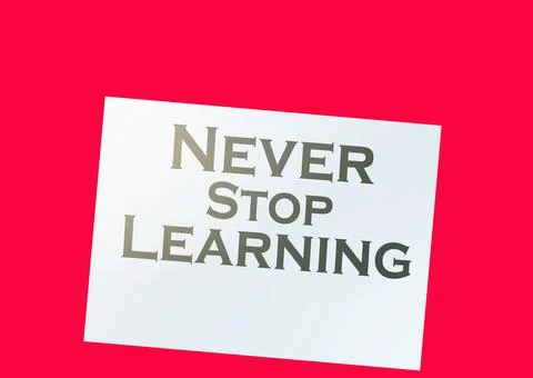 Text never stop learning on page, dollar signs on wood table. education conce Stock Photos