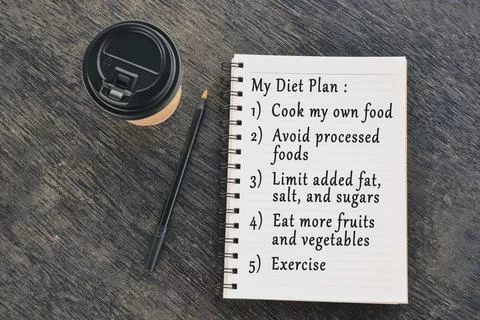 Text on notepad with disposable coffee cup and pen on wooden table Stock Photos