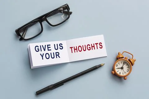Text on notepad with reading glasses, pen and alarm clock on blue background. 库存照片
