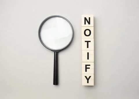 Text notify written on a blue background near a magnifying glass and and a ca Stock Photos