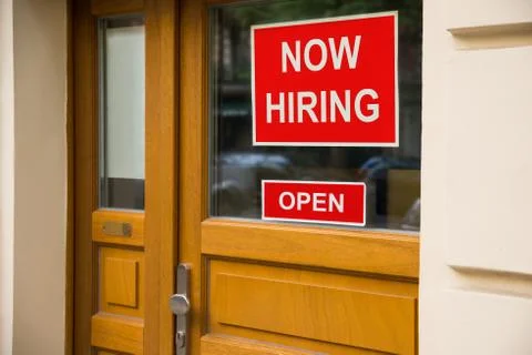 The Text Now Hiring Sticker Attached On Glass Door Of The Office Stock Photos