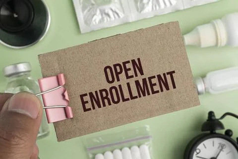 The text open enrollment is written on notepad near a stethoscope on a pape.. Stock Photos