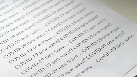 Text on paper about covid-19 new wave Stock Footage 139689405