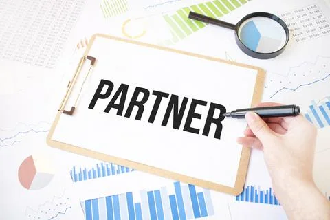 Text PARTNER on white paper sheet and marker on businessman hand on the diagr Stock Photos
