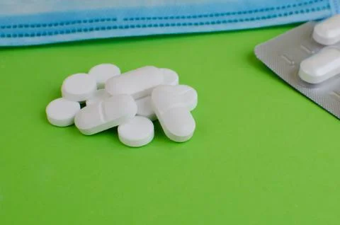 Text phrase Coronavirus on a green background with medicines and protective m Stock Photos