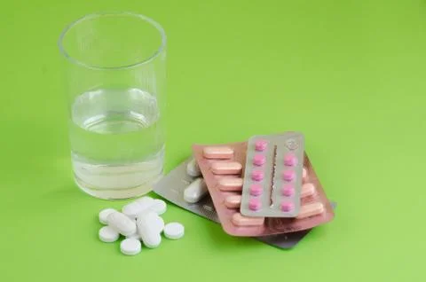 Text phrase Coronavirus on a green background with medicines and protective m Stock Photos