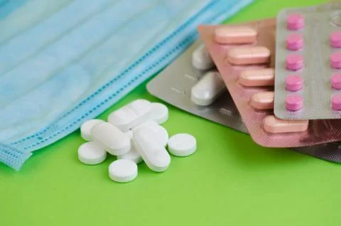 Text phrase Coronavirus on a green background with medicines and protective m Stock Photos