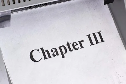 Text printed on paper showing Chapter III in a document being printed in a Stockfoto's