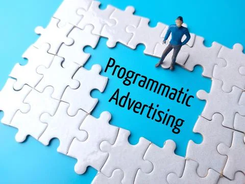 Text Programmatic Advertising written on blue background with white puzzle .. Stock Photos