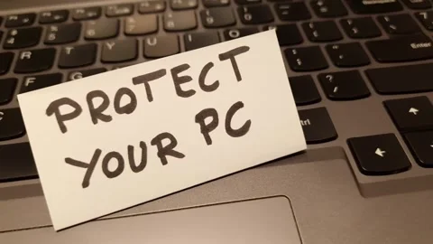 Text protect your pc handwritten on paper note lying on laptop keyboard Stock Footage 297086108