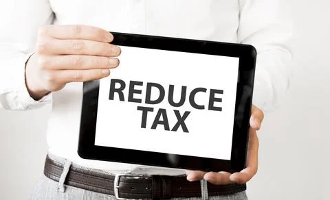 Text REDUCE TAX on tablet display in businessman hands on the white backgro.. Foto stock