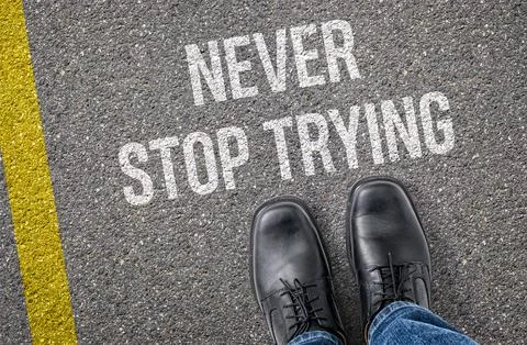 Text on the road - Never stop trying 库存照片