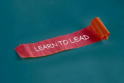 Text on a rolled ribbon emphasizes the importance of learning leadership skil Stock Photos