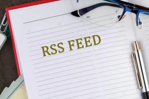 The text RSS FEED stands out on a lined notebook page, surrounded by statione Stock Photos