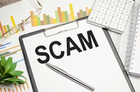 Text scam on paper on the keyboard with office tools Фото