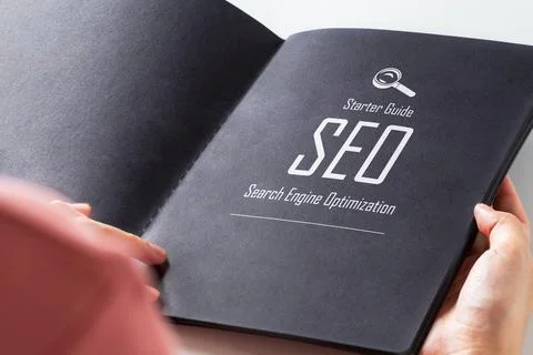 Text " Starter Guide SEO Search Engine Optimization" on page of black book. Stock Photos