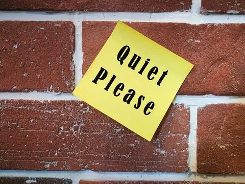 Text on sticky yellow note on brick wall. Quiet please Stock Photos