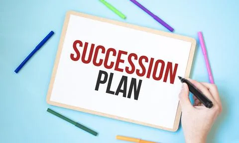 Text SUCCESSION PLAN on a notebook surrounded by colored felt-tip pens, busin Stock Photos