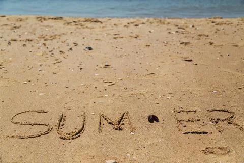 Text Summer Written on the Sand of a Beach. The Sea on a Background of Letters Foto stock