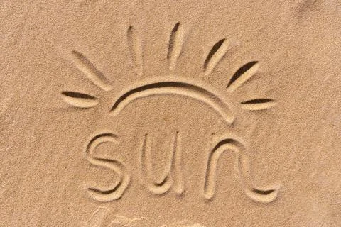 The text "Sun" is handwritten and sun rays are drawn on sandy beach near the sea Stock Photos